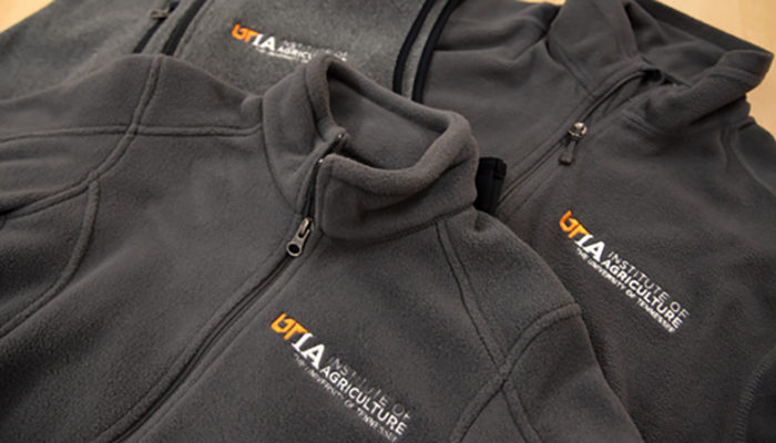 Gray fleece pullovers with the UTIA logo in orange and white on the chest