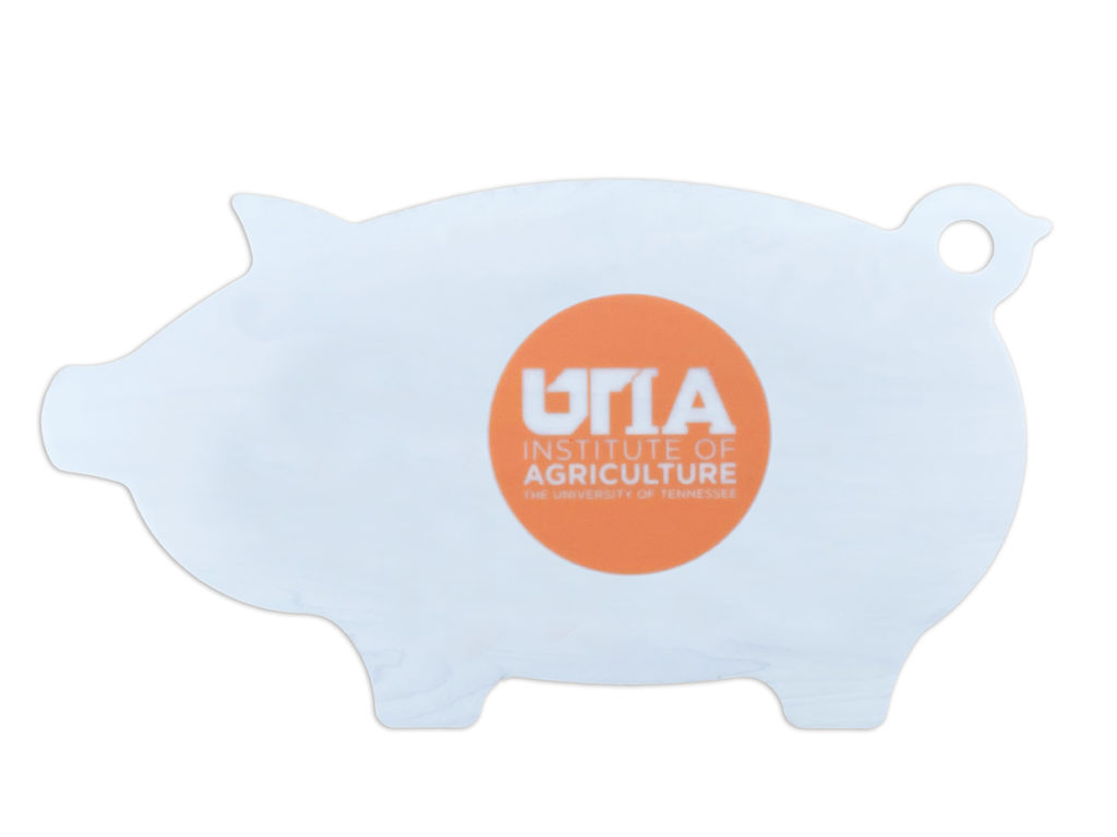 Cutting board shaped like a pig with the UTIA logo in the center